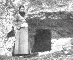 Man at the entrance of a stone tomb