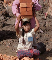 A child being loaded up with bricks