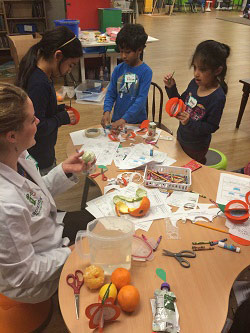 kids making things at a table with a scientist