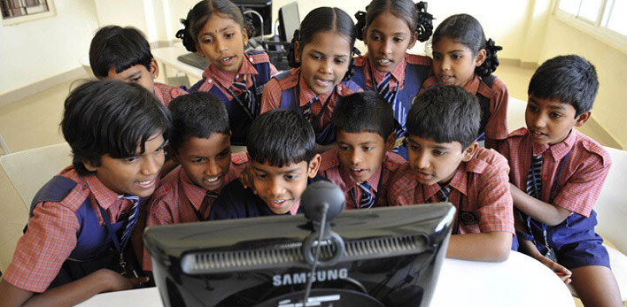 Kids in India gathered around a computer 