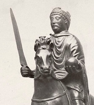 bronze of a man on horseback with a sword in one hand an a ball in the other hand
