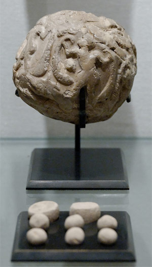 Round clay object with smaller clay pieces that were kept inside the object
