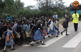group of people crossing a road together, Kenya