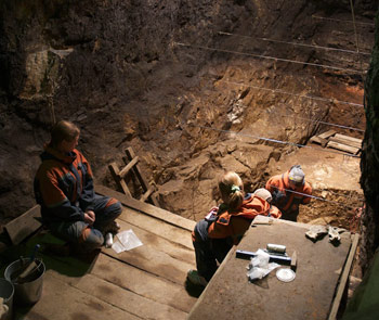 people working at an archeological dig in a cave