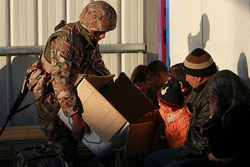 Lebanese soldier offering children toys from a box