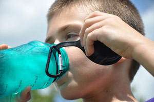 boy drinking out of a plastic water container