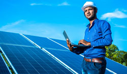 man standing next to solar panels