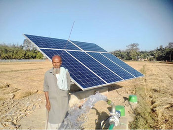 man standing next to solar panels