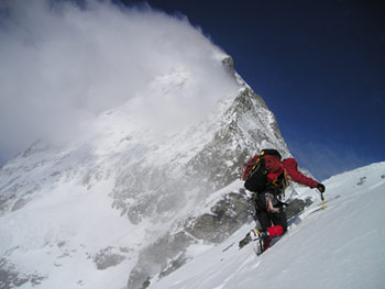 mountain climber nearing a snowy peak