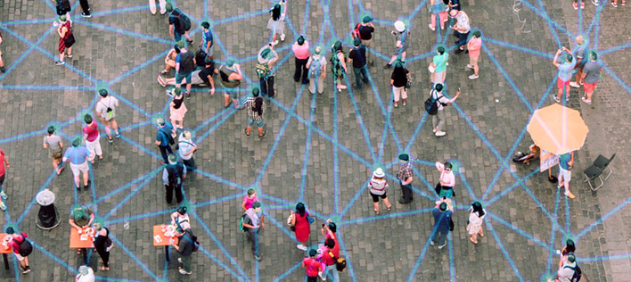people standing in a town square with connecting lines between them