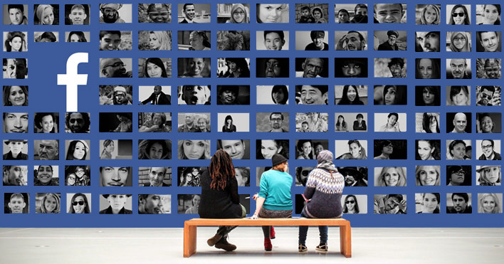 people sitting in front of a wall of faces