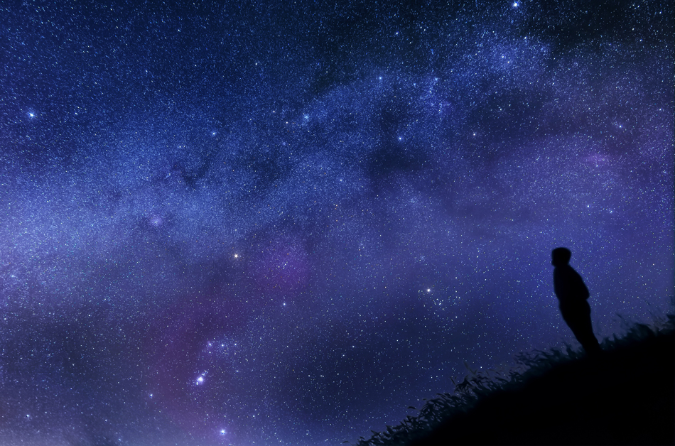 A man looking out at the stars of the night sky.