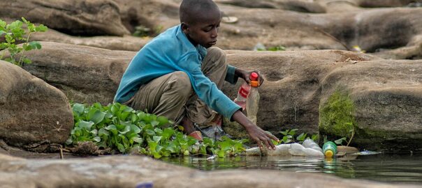 A boy in West Africa removes plastic bottles from the Benue River.