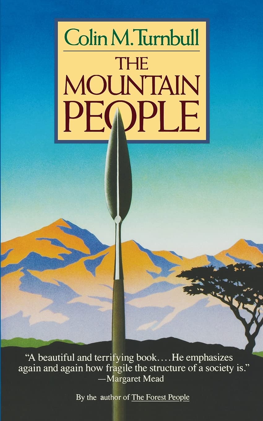 The cover of Colin Turnbull's book, 'The Mountain People', showing a tribal spear with the mountains of Africa in the background.