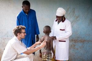 Community health workers assisting a boy in Africa.