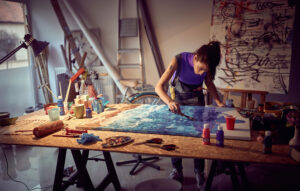 A female artist painting in her studio.