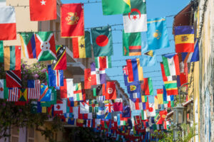 Flags of many countries of the world hang over an alleyway in Latin America.