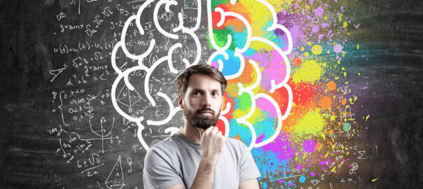 A man standing in front of a diagram of the right and left hemisphere of the brain.