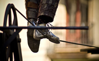 A close-up photo showing a tightrope walker's feet on the high-wire during a circus act practice.